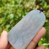 a hand holding a small piece of white stone with a bug on it