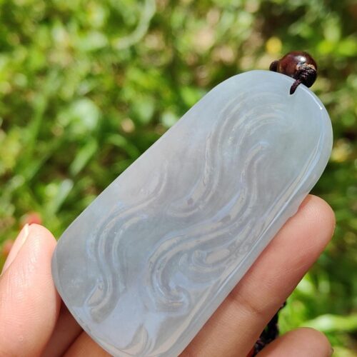 a hand holding a small piece of white stone with a bug on it