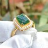 a gold ring with a green stone on it