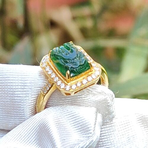 a gold ring with a green stone on it