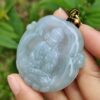 Una mano sosteniendo un colgante de jade.