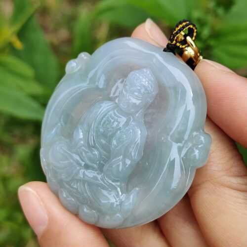 Una mano sosteniendo un colgante de jade.