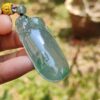 Una mano sosteniendo un colgante de jade.
