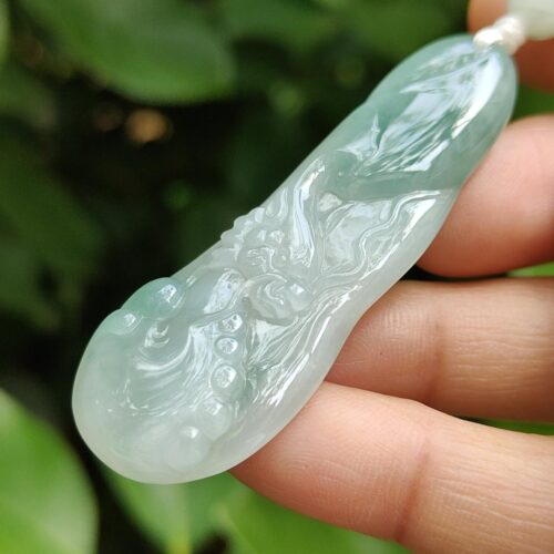a hand holding a jade necklace
