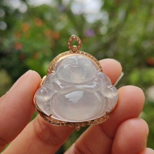 a hand holding a jade pendant