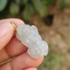 Una mano sosteniendo un colgante de jade.