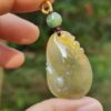 Una mano sosteniendo un colgante de jade.