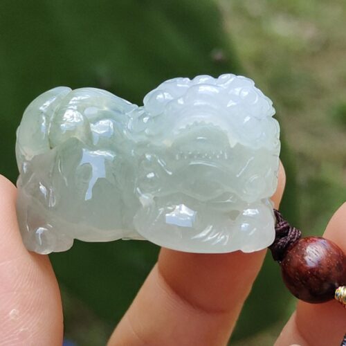 Una mano sosteniendo un colgante de jade.