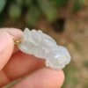 Una mano sosteniendo un colgante de jade.