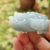 a hand holding a jade frog