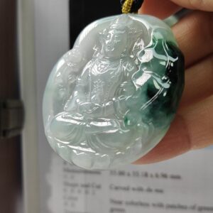 Una mano sosteniendo un colgante de jade.