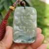 Una mano sosteniendo un colgante de jade.