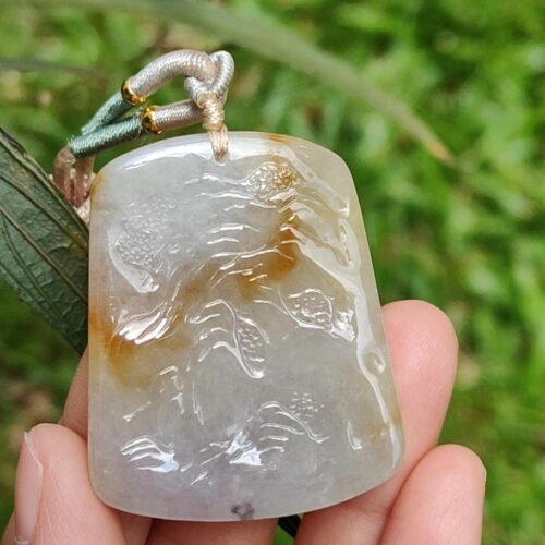 Una mano sosteniendo un colgante de jade.