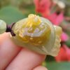 Una mano sosteniendo un colgante de jade.