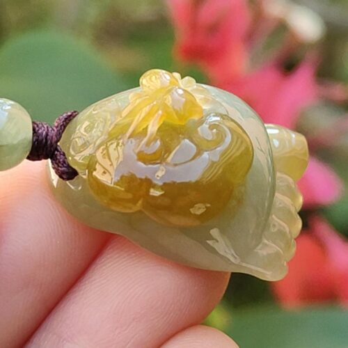Una mano sosteniendo un colgante de jade.