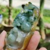 a hand holding a jade sculpture