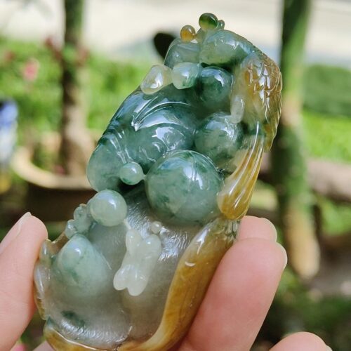 a hand holding a jade sculpture