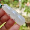 una mano sosteniendo una cuenta de jade