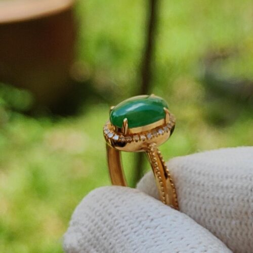 a hand wearing a glove holding a ring