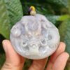 Una mano sosteniendo un colgante de piedra.