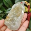 a hand holding a jade pendant