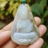 a hand holding a jade pendant