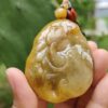 a hand holding a jade pendant