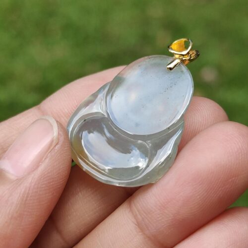 a hand holding a small clear object