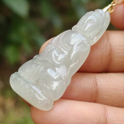 a hand holding a jade pendant