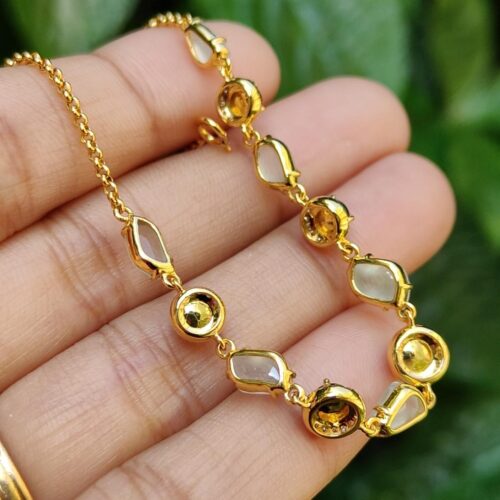 a hand holding a gold necklace