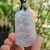 Una mano sosteniendo un colgante de jade.