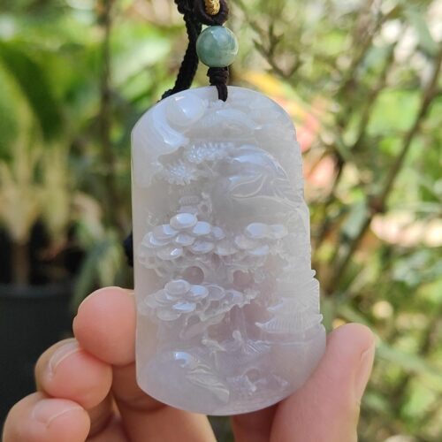 Una mano sosteniendo un colgante de jade.