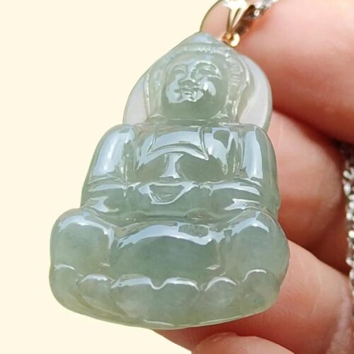 a hand holding a jade pendant