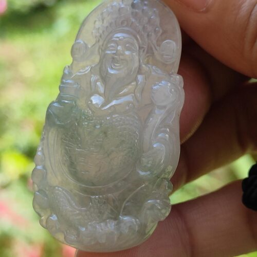 a hand holding a jade carving