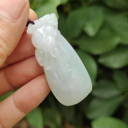 ஜேட் பதக்கத்தை வைத்திருக்கும் ஒரு கை