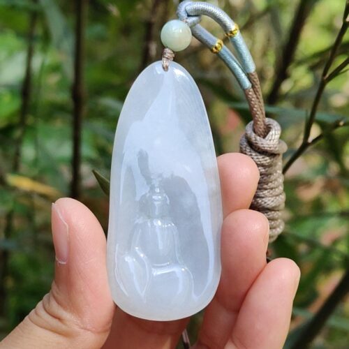 a hand holding a jade pendant