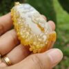 a hand holding a yellow and white stone