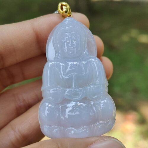a hand holding a white jade pendant