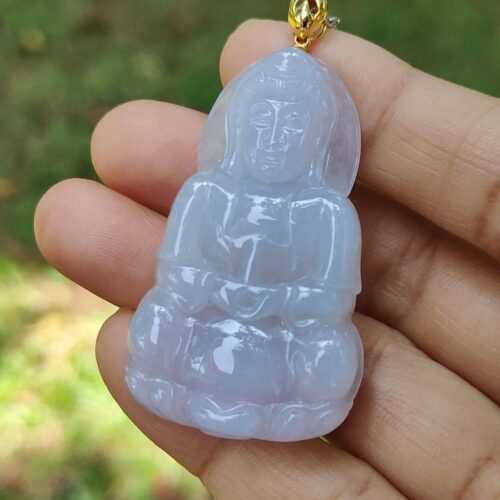 a hand holding a jade pendant