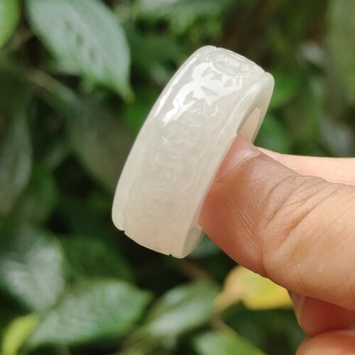 a finger holding a white ring