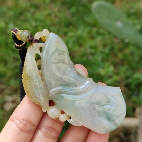 Una mano sosteniendo un colgante de jade.