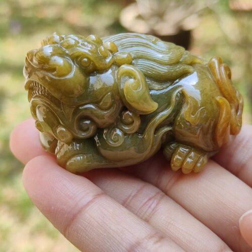 a hand holding a small green animal