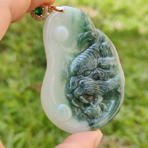 une main tenant un pendentif en jade