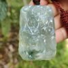 Una mano sosteniendo un colgante de jade.