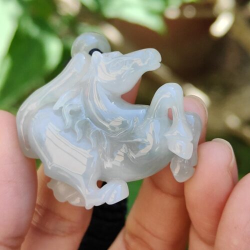 a hand holding a small white horse