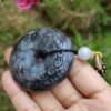 a hand holding a stone necklace