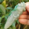 Una mano sosteniendo un dragón de jade