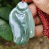 a hand holding a jade necklace