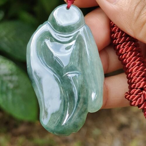 a hand holding a jade necklace