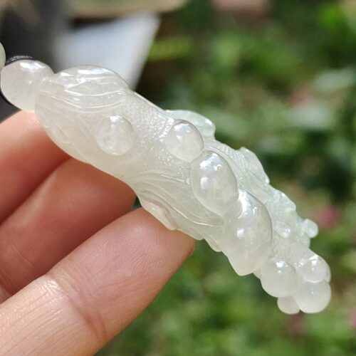 a hand holding a white jade object